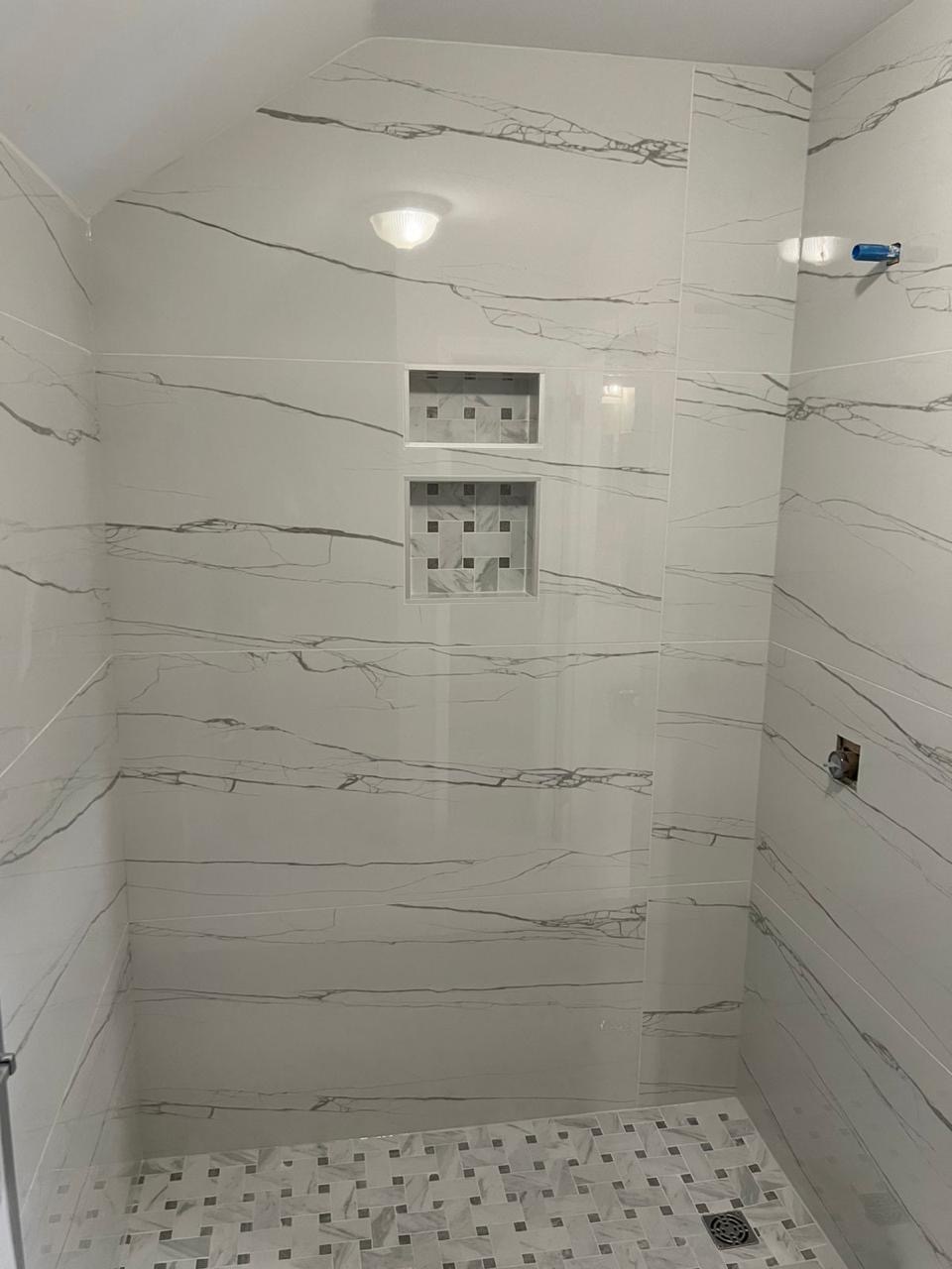 Finished marble-look porcelain tile shower with built-in niches installed by BBJ Flooring Corp