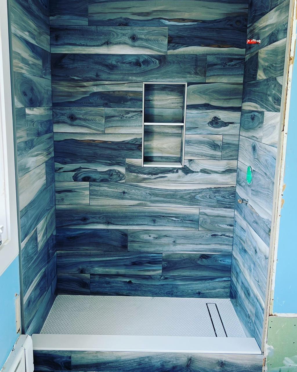Wood-look porcelain tile shower mid-installation by BBJ Flooring Corp